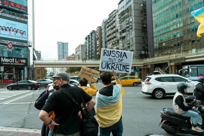 a group of people standing on the side of a road, unsplash, socialist realism, sanctions in russia, protesters holding placards, yellow, 🚿🗝📝