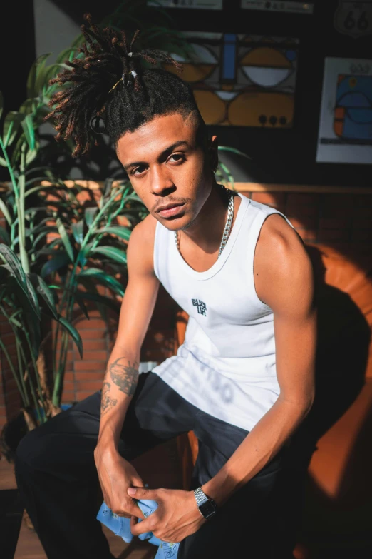 a young man sitting on top of a wooden bench, an album cover, trending on unsplash, visual art, white tank top, portrait of hisoka hunter hunter, são paulo, standing in a dimly lit room