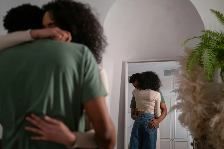 a woman hugging a man in a living room, trending on pexels, renaissance, view from behind mirror, with brown skin, full body image, lgbtq