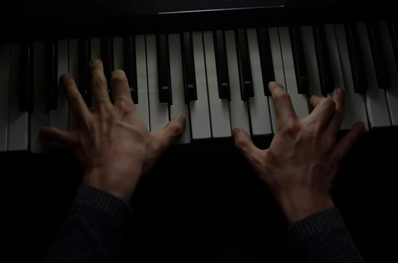 a close up of a person playing a piano, inspired by Bryan Organ, massurrealism, photorealistic logan movie still, closed hands, taken with sony alpha 9, it's getting dark