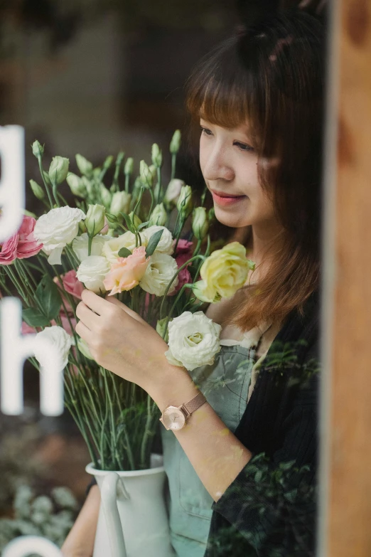 a woman holding a vase of flowers in front of a window, by Tan Ting-pho, trending on unsplash, wearing a watch, flower shop scene, close up iwakura lain, cute and lovely