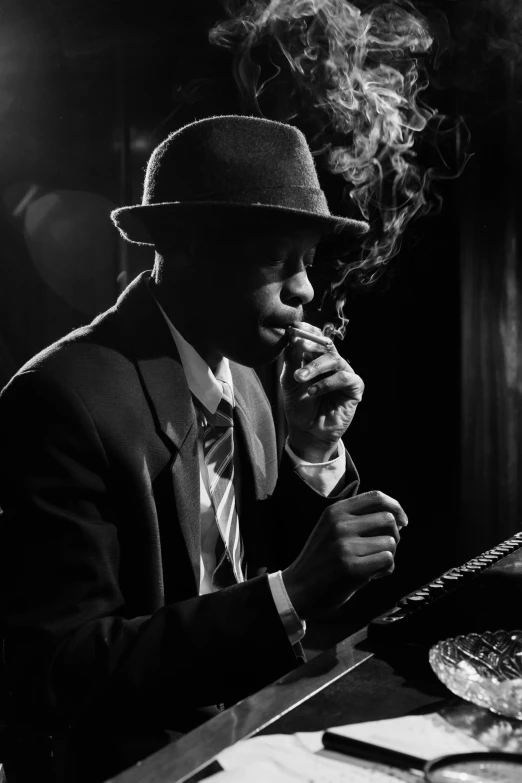 a man sitting at a table smoking a cigarette, a black and white photo, inspired by George Bogart, unsplash, harlem renaissance, energetic jazz piano portrait, noir detective and a fedora, blue velvet, dave chappelle