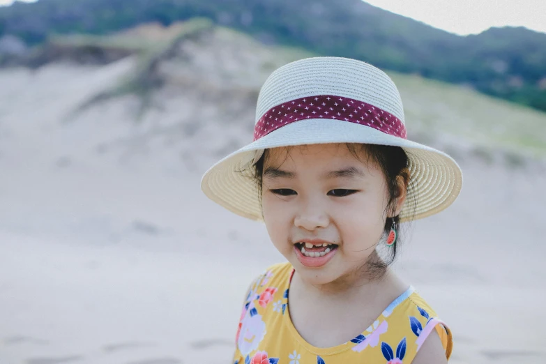 a little girl standing on top of a sandy beach, pexels contest winner, mingei, it's wearing a cute little hat, avatar image, asian descent, teeth