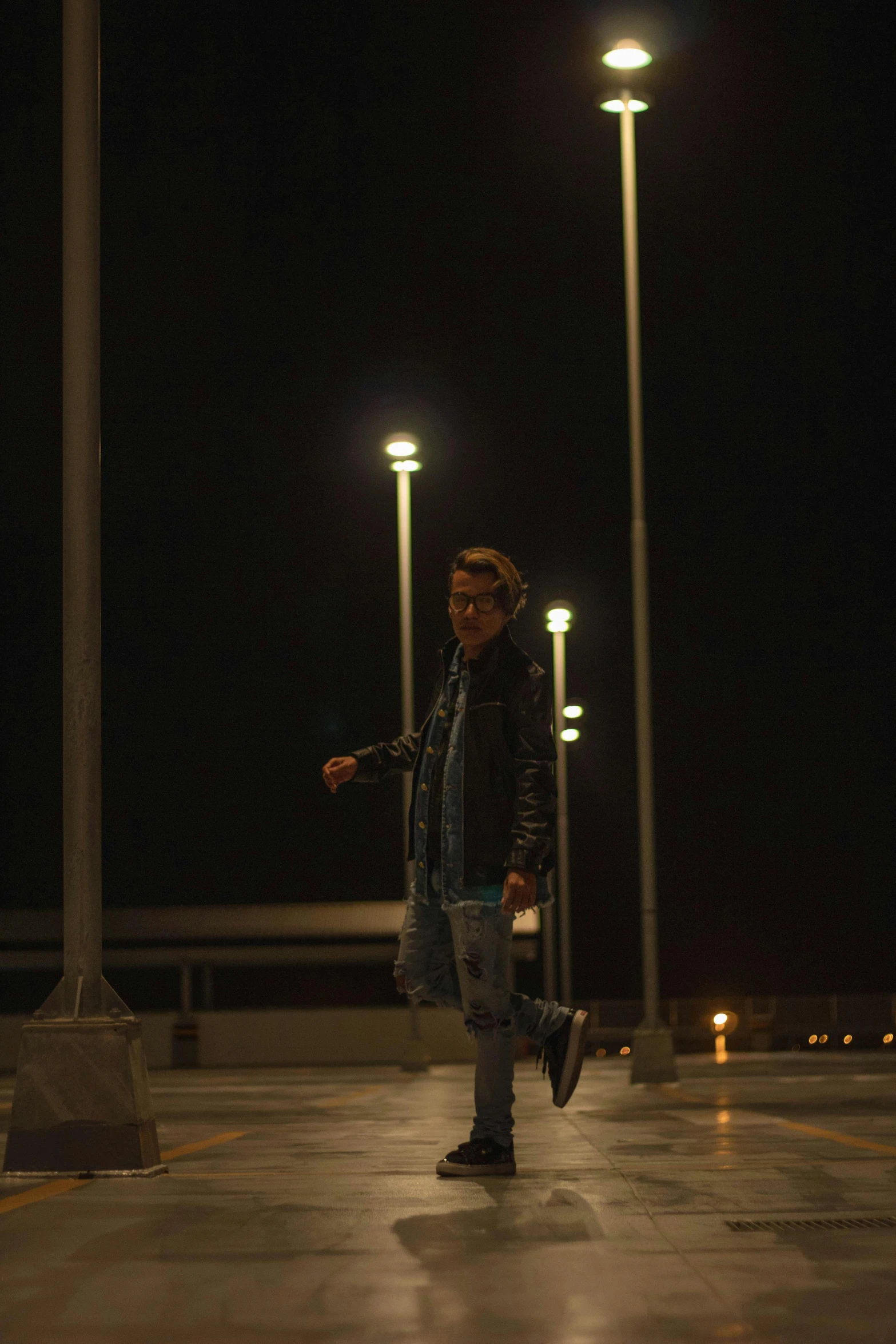 a man walking across a parking lot at night, a picture, happening, frank dillane, low quality photo, raphael personnaz, lut