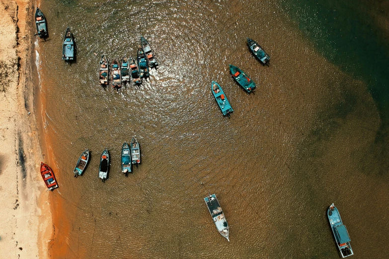 a group of boats sitting on top of a sandy beach, by Adam Marczyński, pexels contest winner, hurufiyya, satellite imagery, river, fish flocks, thumbnail