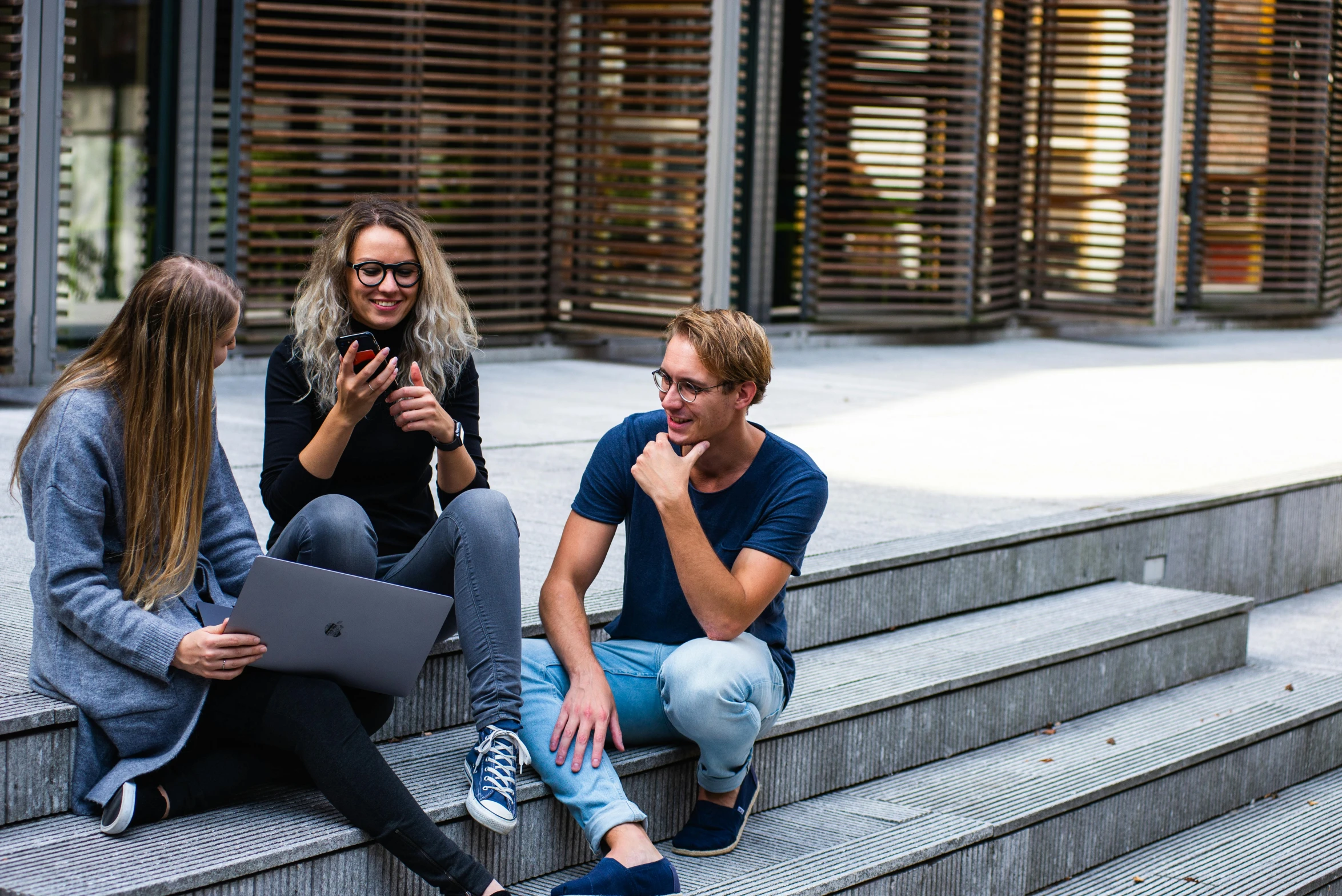 three people sitting on steps looking at a laptop, pexels contest winner, happening, university, australian, high tech concrete bench cube, rectangle