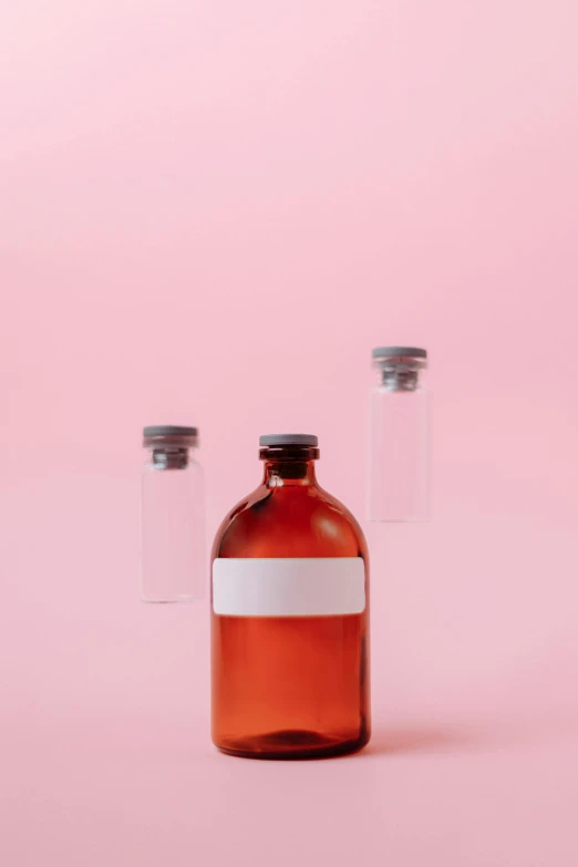 a bottle of liquid on a pink background, by Andries Stock, trending on pexels, antipodeans, blood collection vials, tan, surgeon, a blond