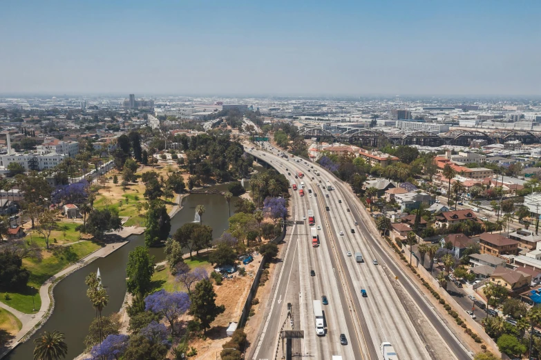 a freeway filled with lots of traffic next to a river, unsplash, photorealism, 1600 south azusa avenue, city views, [ 4 k photorealism ], overview