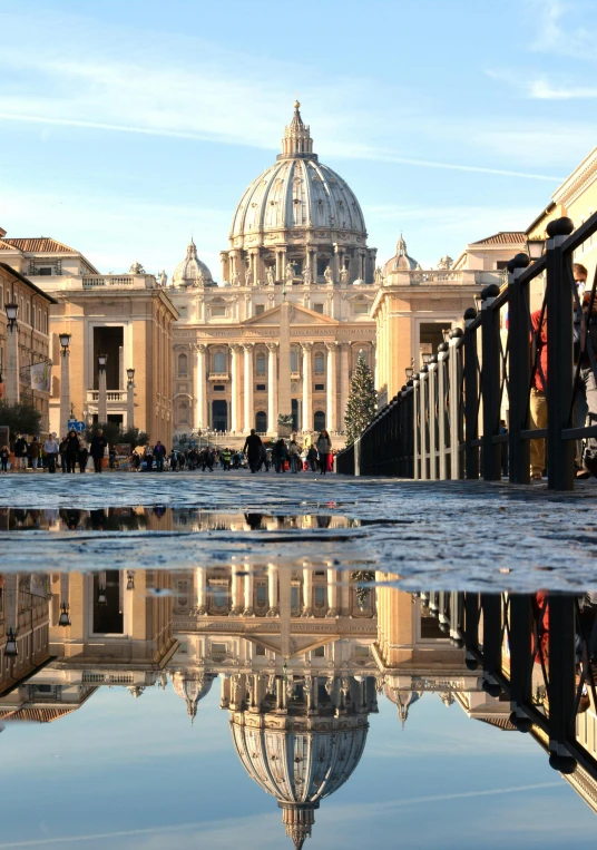 a reflection of a building in a puddle of water, by Cagnaccio di San Pietro, pexels contest winner, renaissance, vatican in background, 2 5 6 x 2 5 6 pixels, slide show, people walking around