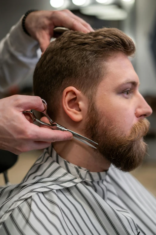 a man getting his hair cut at a barber shop, trending on reddit, sharp jawline with a light beard, paul barson, photo of a model, angle face