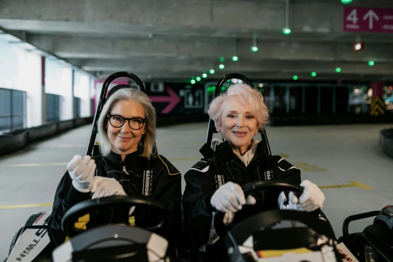 a couple of women standing next to each other, bumper cars, formula 1 garage, dementia, black and yellow scheme