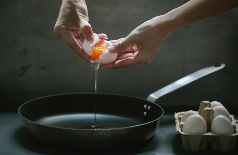 a person squeezing an egg into a frying pan, by Jessie Algie, trending on unsplash, process art, dwell, ingredients on the table, filling with water, sasai ukon masanao