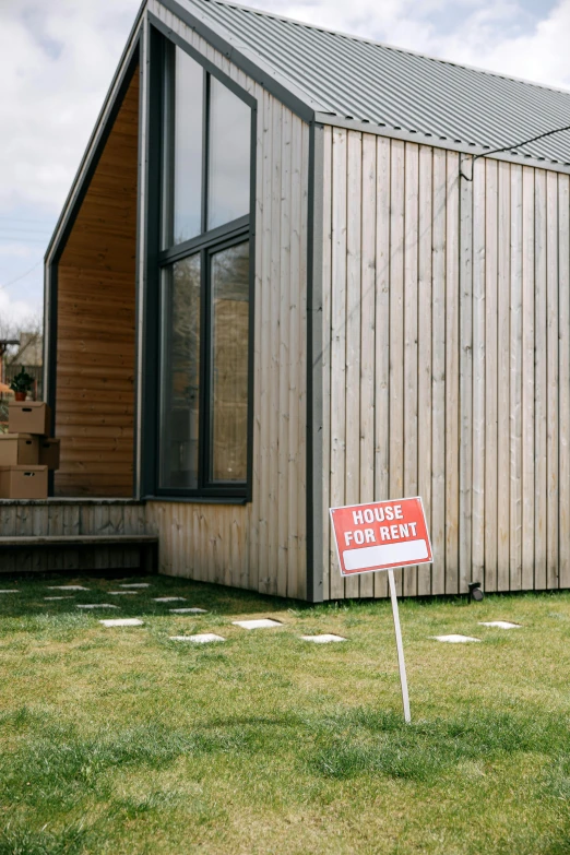 a house with a for sale sign in front of it, by Rachel Reckitt, unsplash, modernism, stood outside a wooden cabin, dezeen showroom, lawn, sustainable materials
