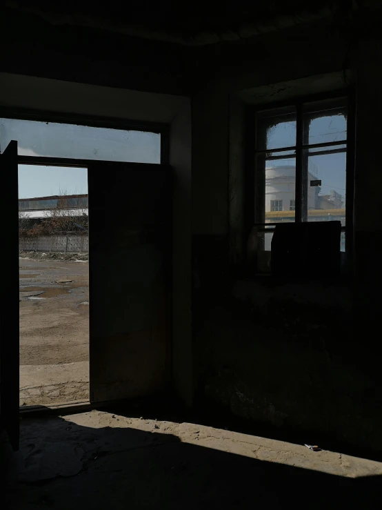 an open door in a run down building, an album cover, by Attila Meszlenyi, unsplash, window ( city ), hangar, escape from tarkov, low quality photo