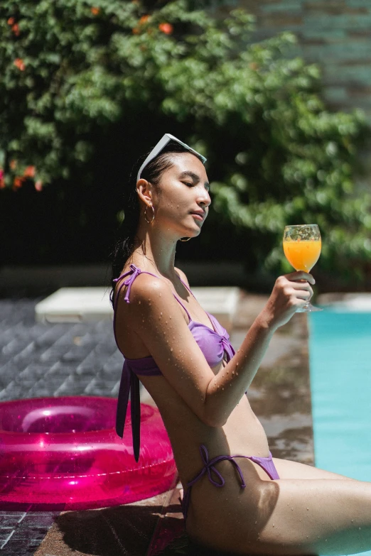 a woman sitting in a pool holding a glass of orange juice, instagram, renaissance, purple, asian woman, holiday vibe, profile image