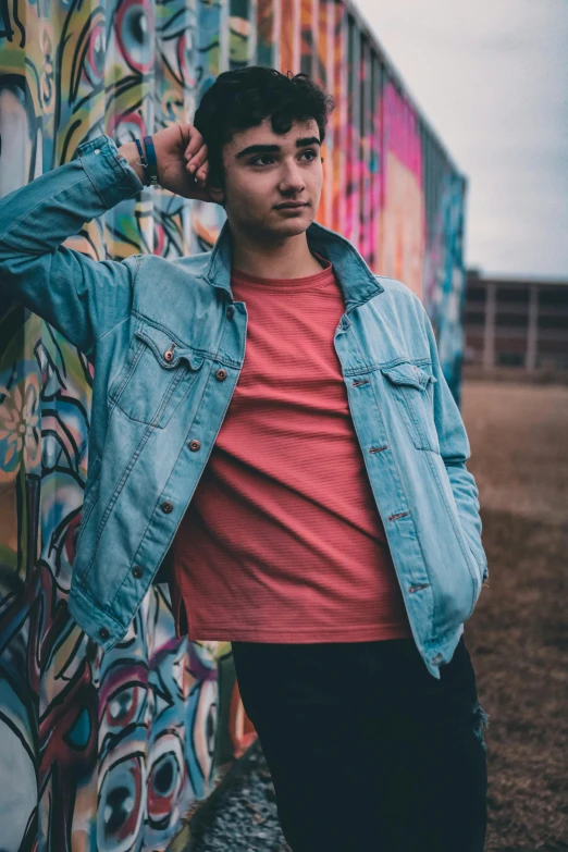 a man leaning against a graffiti covered wall, a picture, by Adam Dario Keel, discord profile picture, non binary model, jean jacket, profile image