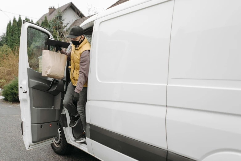 a man standing in the open door of a van, pexels, renaissance, getting groceries, avatar image, wearing hi vis clothing, brown