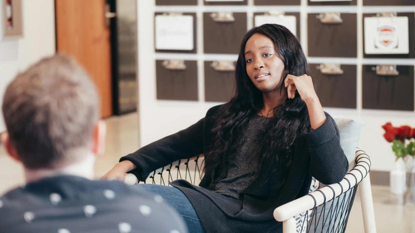 a woman sitting in a chair talking on a cell phone, emmanuel shiru, aida muluneh, profile image, teaching