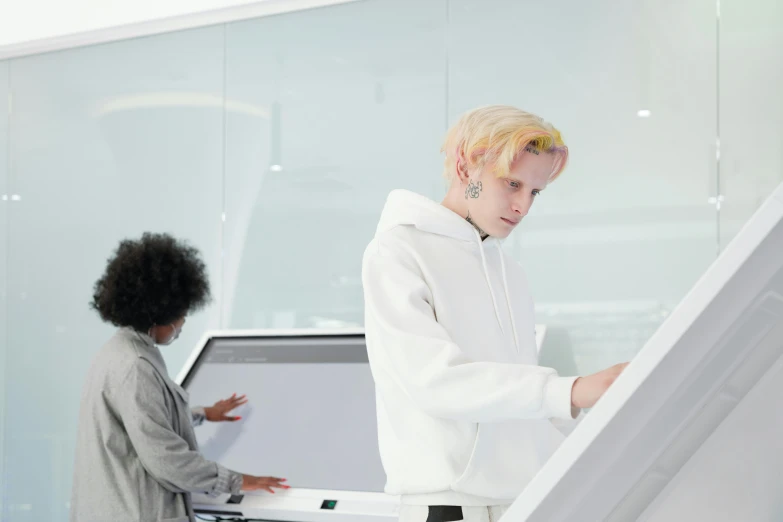 a woman standing in front of a laptop computer, by Jacob Toorenvliet, trending on pexels, albino hair, portrait of two people, on a spaceship, whiteboards