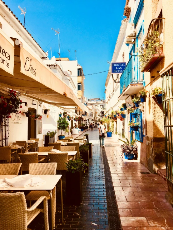 a narrow street lined with tables and chairs, by Julia Pishtar, marbella, profile image, at the terrace, thumbnail