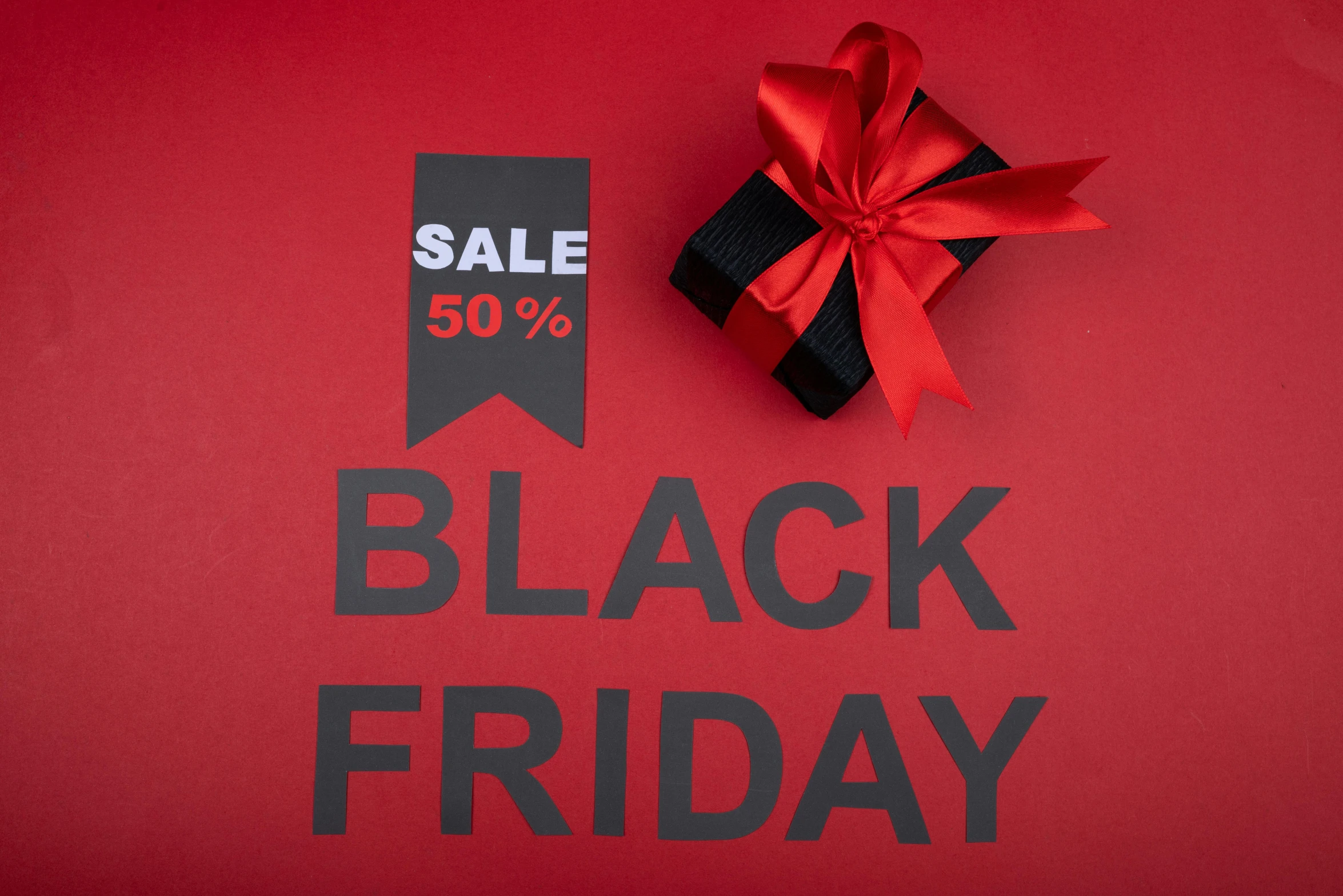 a black friday sale sign with a red ribbon, a photo, by Elaine Hamilton, shutterstock, hurufiyya, black jewellery, 50, black matte finish, burberry