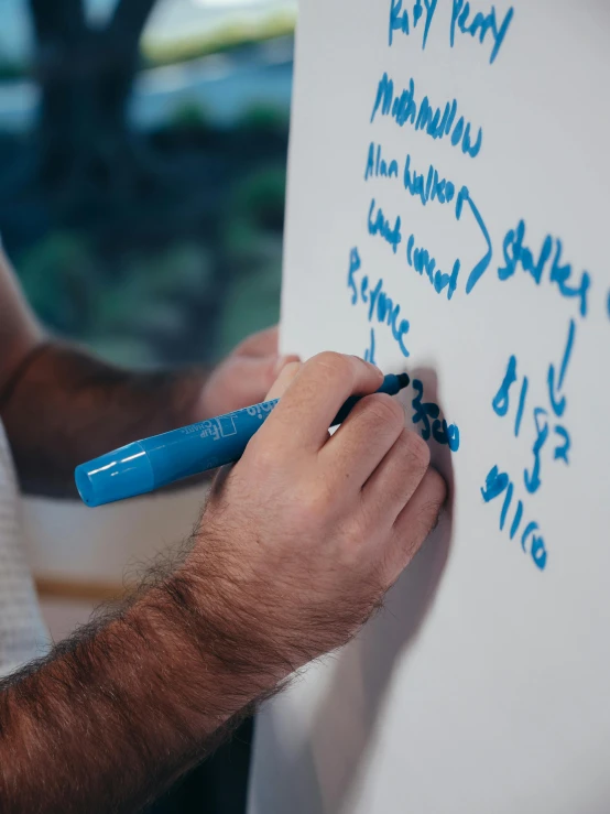 a man writing on a white board with a blue marker, by Adam Marczyński, up close image, callouts, multiple stories, thumbnail