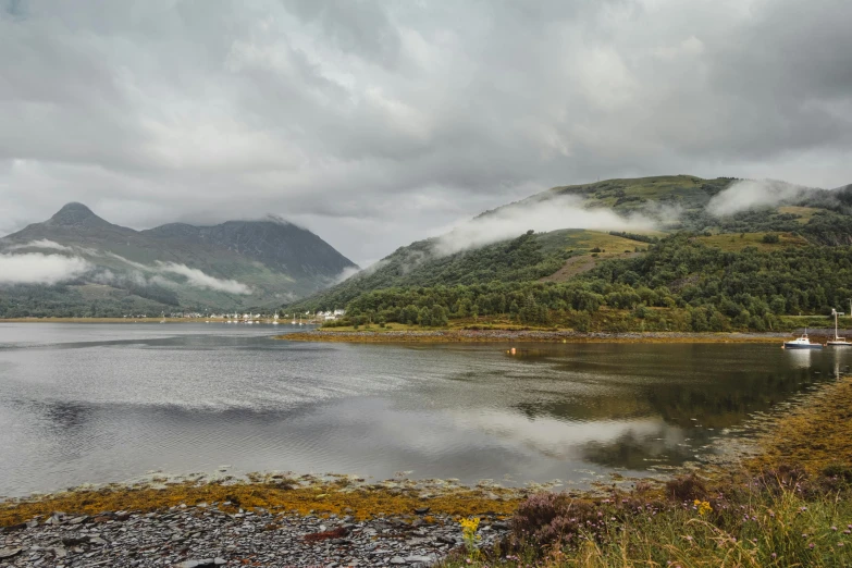 a body of water with mountains in the background, by Andrew Allan, pexels contest winner, low clouds after rain, scottish style, multiple stories, river and trees and hills