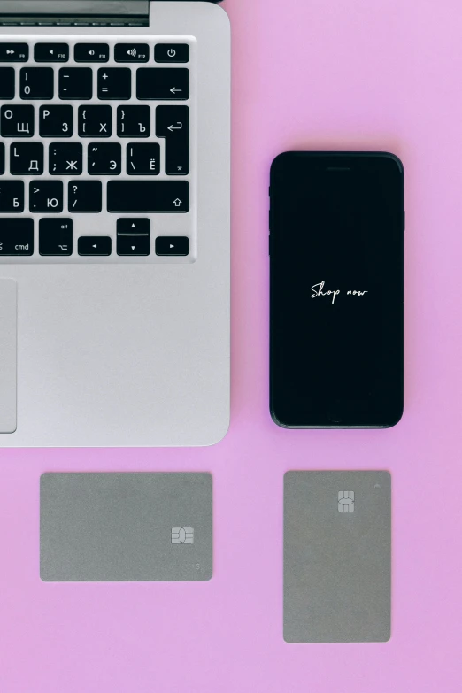 a laptop computer sitting on top of a pink surface, by Adam Rex, trending on pexels, corporate phone app icon, square, pair of keycards on table, slay