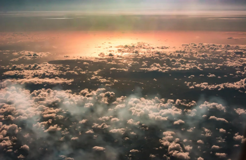 the sun is setting over the clouds as seen from an airplane, by Jacob Toorenvliet, pexels contest winner, romanticism, pink storm clouds, high above the ground, fractal cloud, dreamy hazy