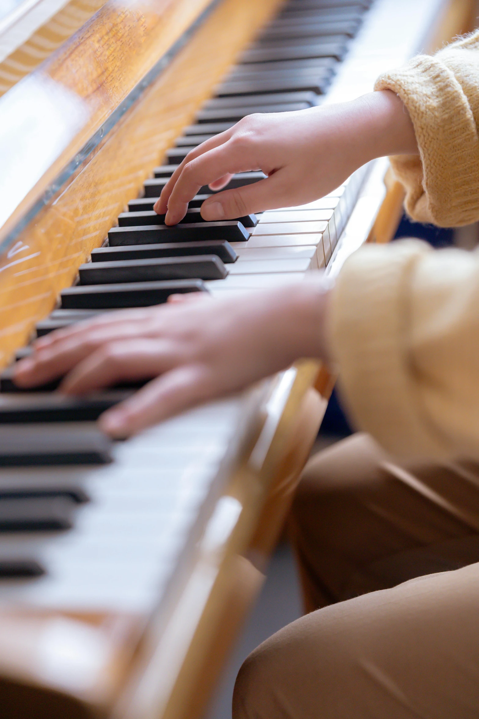 a close up of a person playing a piano, mild colours, student, brown, louise zhang