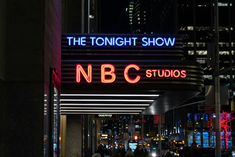 a large neon sign on the side of a building, television show, during the night, nbc, promotional image