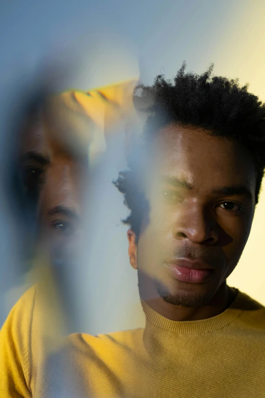 a close up of a person behind a fence, an album cover, inspired by Gordon Parks, pexels contest winner, black arts movement, wearing a modern yellow tshirt, looking in mirror, flume, soft light.4k
