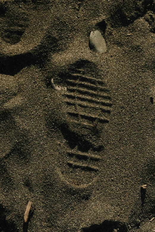 a pair of footprints in the sand on a beach, inspired by Andy Goldsworthy, unsplash, rubber waffle outsole, on black background, face covered in dirt, technologies