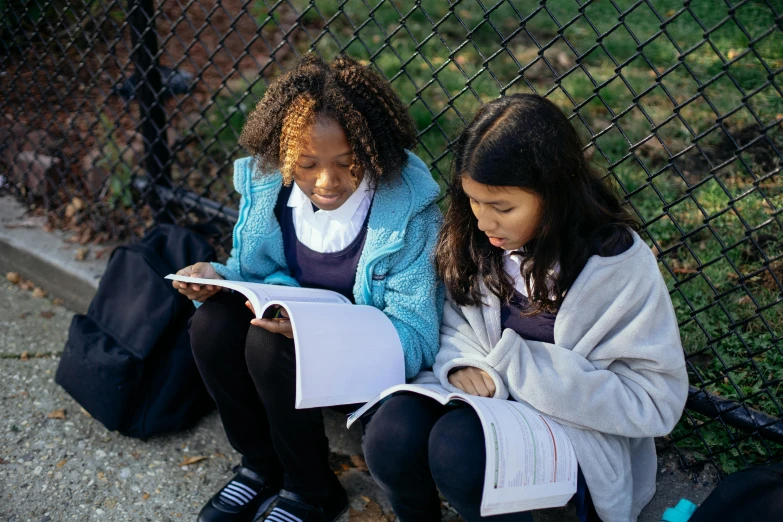 two girls sitting on the ground reading books, trending on unsplash, ashcan school, sitting on a bench, photographed for reuters, school curriculum expert, in a medium full shot