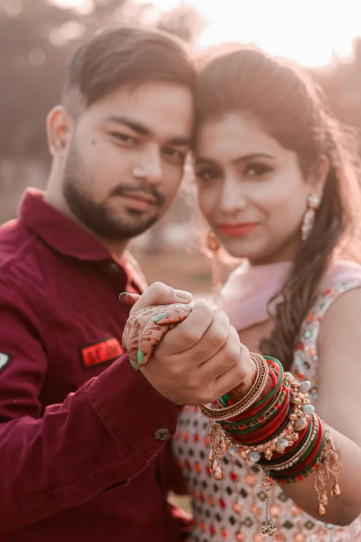 a man and woman standing next to each other, a picture, by Rajesh Soni, pexels contest winner, bracelets, square, engagement ring ads, warm glow