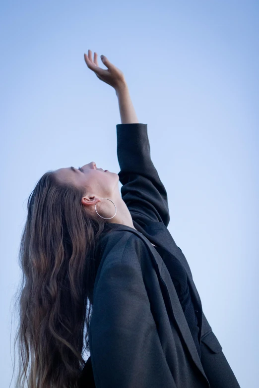 a woman reaching up to catch a frisbee, unsplash, happening, young female in black tuxedo, doing a prayer, looking upwards, wearing an academic gown