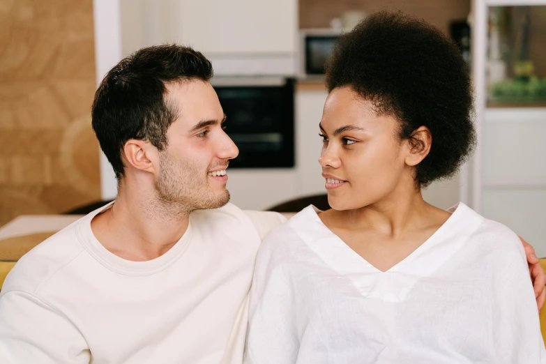 a man and a woman sitting on a couch, trending on pexels, renaissance, profile pic, with brown skin, charming smile, looking from shoulder