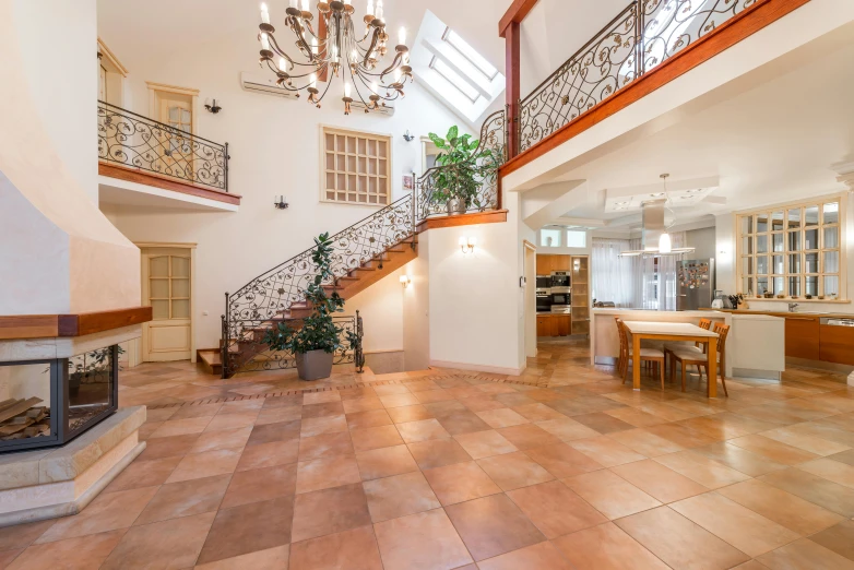 a living room filled with furniture and a fire place, by Alexander Fedosav, unsplash, art nouveau, stone tile hallway, large staircase, light tan, polish mansion kitchen