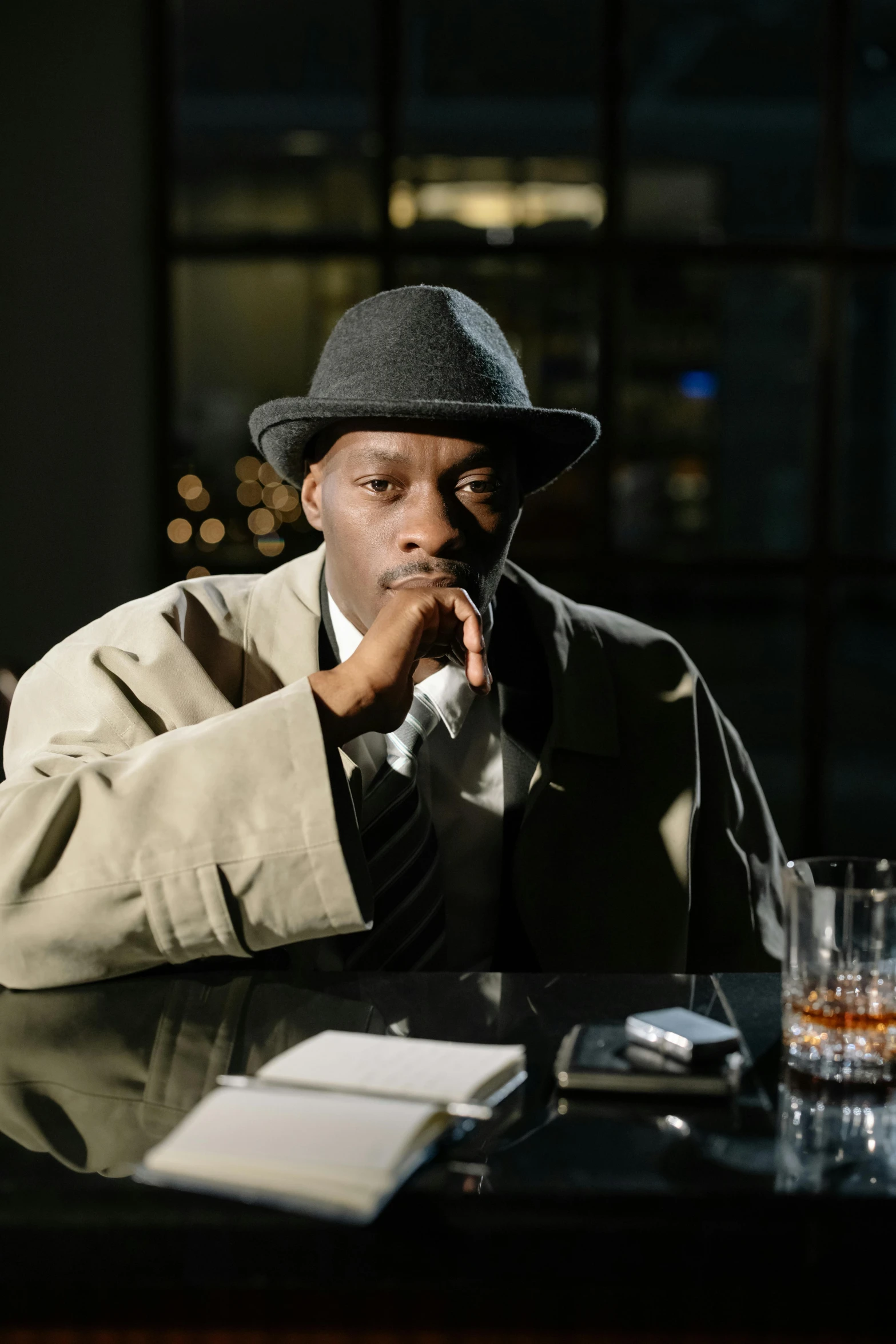 a man in a hat sitting at a bar, inspired by William Grant Stevenson, unsplash, harlem renaissance, detective clothes, ( ( theatrical ) ), lance reddick, pulp fiction style