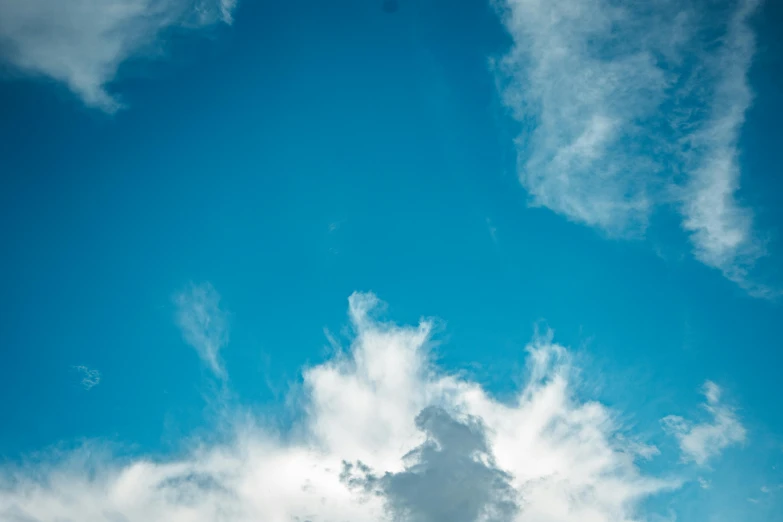 a man riding a snowboard on top of a snow covered slope, an album cover, unsplash, minimalism, tall fluffy clouds, sky blue, viewed from below, cloudless-crear-sky