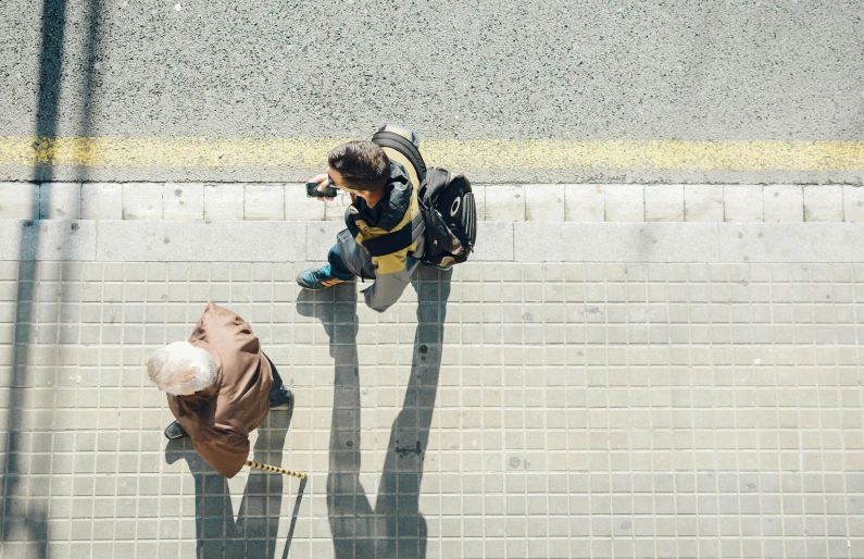 a couple of people sitting on the side of a road, pexels contest winner, not a messenger from above, old man, crosswalk, in spain