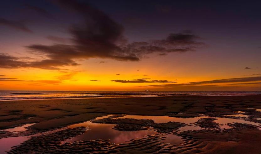 a large body of water sitting on top of a sandy beach, by Andries Stock, pexels contest winner, the colours of the sunset, thumbnail, reflection, today\'s featured photograph 4k