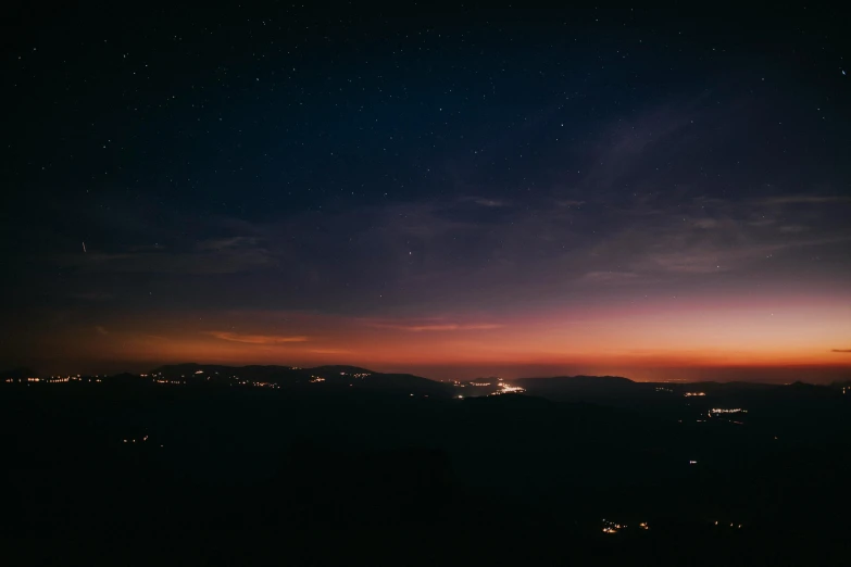 a view of a city at night from the top of a hill, pexels contest winner, ☁🌪🌙👩🏾, sunset in a valley, space photo, midnight colors