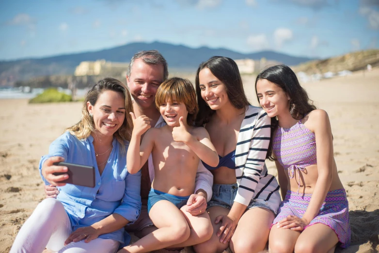 a group of people sitting on top of a sandy beach, a picture, avatar image, families playing, 8k selfie photograph, spanish