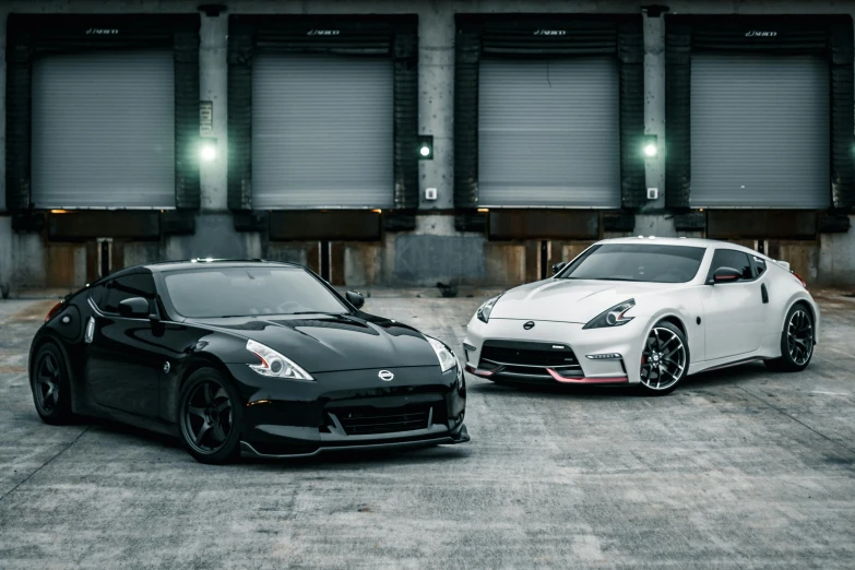 two sports cars parked side by side in a parking lot, a portrait, inspired by Nōami, unsplash, 9 9 designs, posing for camera, black and reddis, drifting around a corner