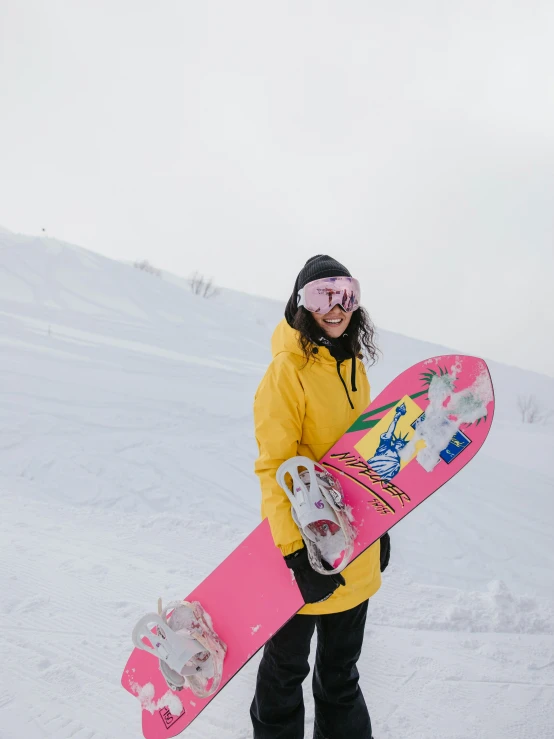 a woman in a yellow jacket holding a pink snowboard, by Julia Pishtar, pexels contest winner, snow camouflage, low quality photo, 🚿🗝📝