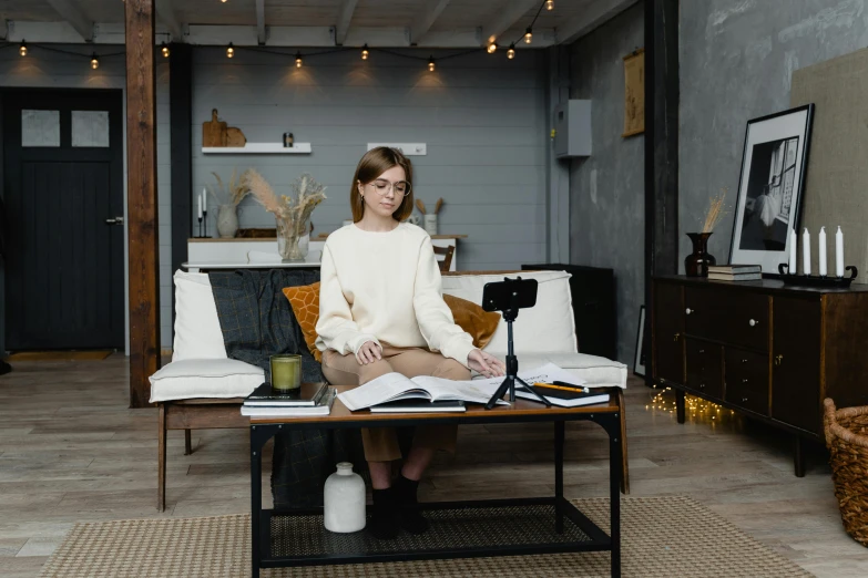 a woman sitting on a couch in a living room, trending on pexels, standing on a desk, behind the scenes photo, low ceiling, gorecore