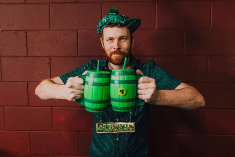 a man holding two green mugs in front of a brick wall, barrel chested, the ultimate gigachad, mixing drinks, full costume