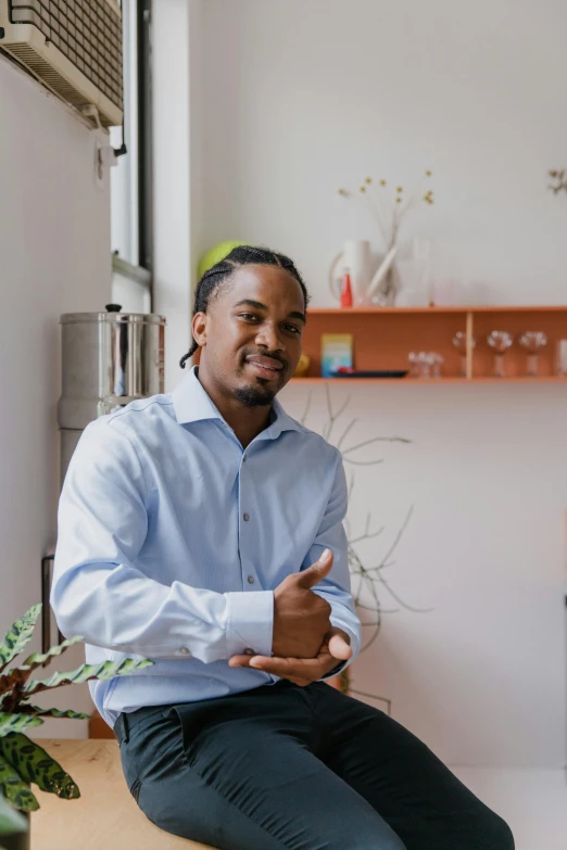 a man sitting on top of a table next to a window, a portrait, pexels contest winner, jemal shabazz, in an office, on clear background, in a kitchen