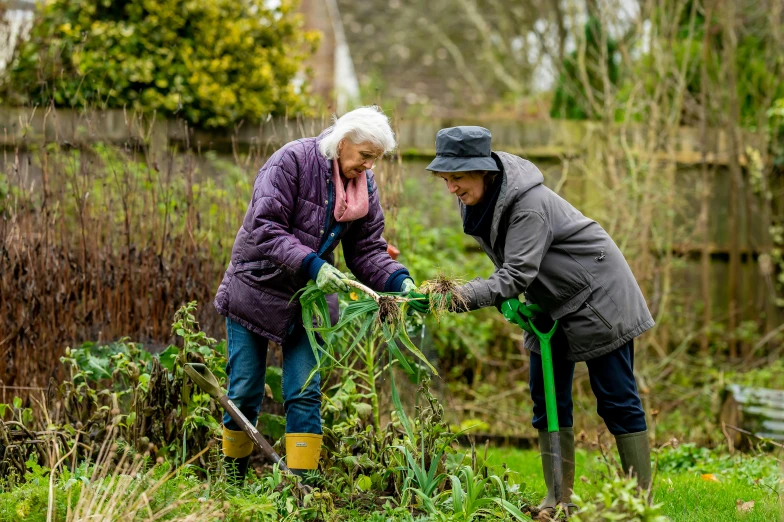 a couple of people that are standing in the grass, using a spade, biodiversity all round, older woman, february)